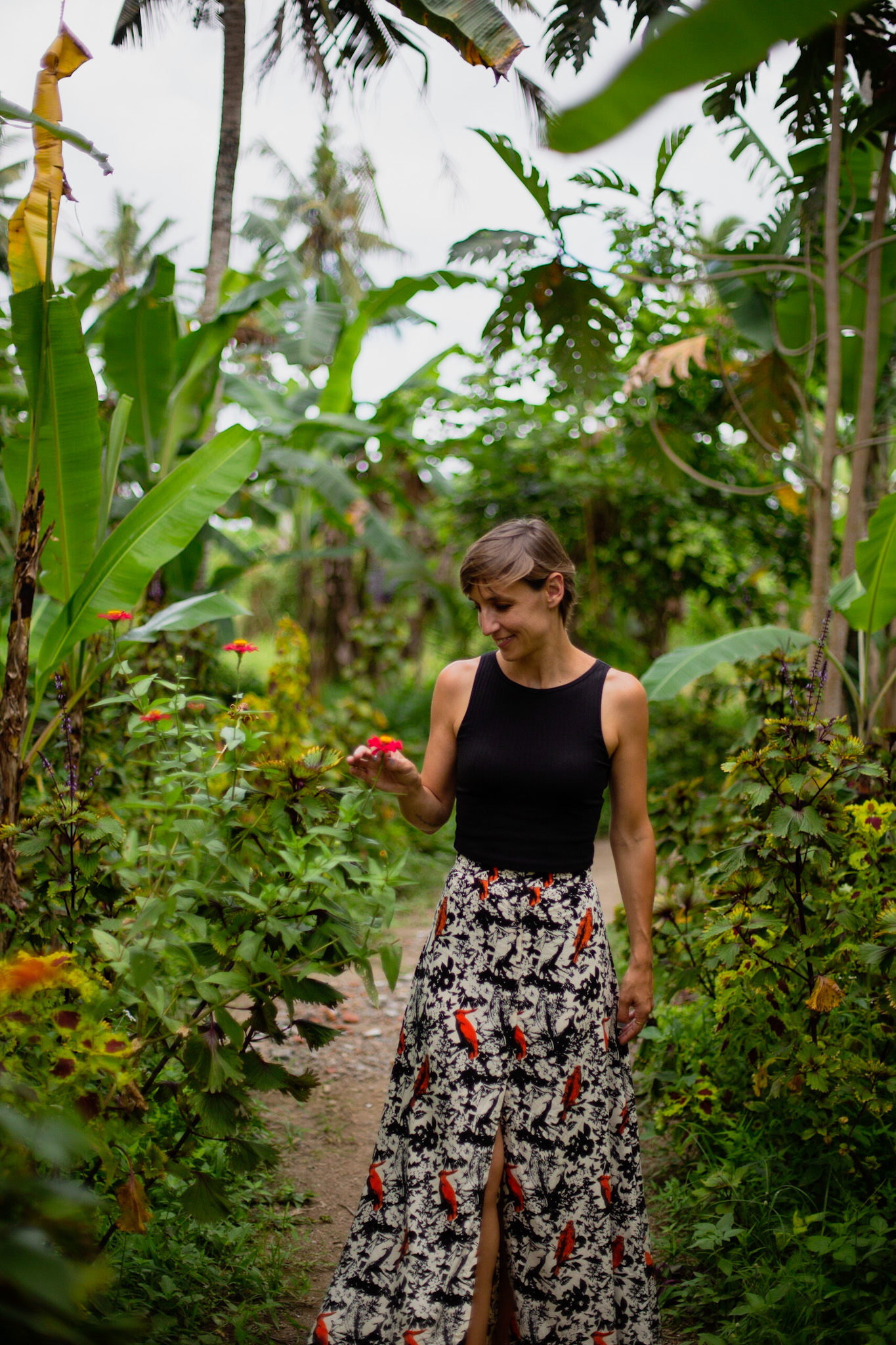 Léa se balade dans un jardin avec une fleur à la main